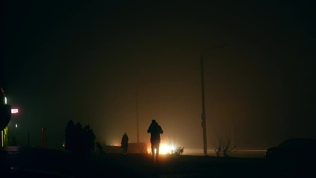 Silhouettes of people in the darkness of the streets at blackout time. War in Ukraine and crisis in energetic system from power stations bombing.
