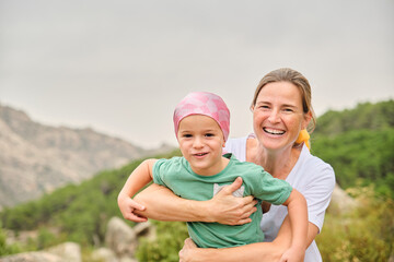 Portrait of a mother and child with cancer having fun in nature