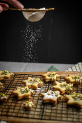 selbst gebackene Plätzchen mit Puderzucker bestreuen, Backen Weihnachten, Weihnachtsbäckerei, 