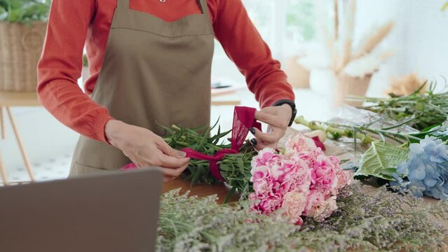 Closeup Female florist hands making bunch at flower shop. Pink Carnation, Small business owner, entrepreneur