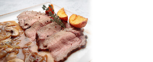 Baked veal with potatoes and mushrooms in sauce. Banner