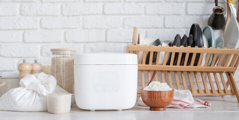 Electric rice cooker on wooden counter-top in the kitchen