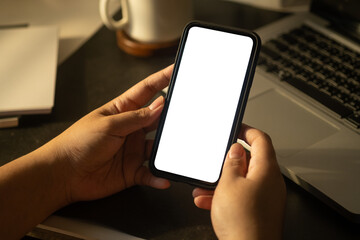 Woman using smart phone over working desk. Close up view, Empty screen for your advertise design.