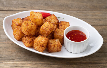 Tapioca dice, typical northeast brazilian food with chilli pepper syrup over wooden table
