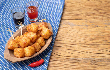 Tapioca dice, typical northeast brazilian food with chilli pepper and sugar syrup over wooden table with copy space