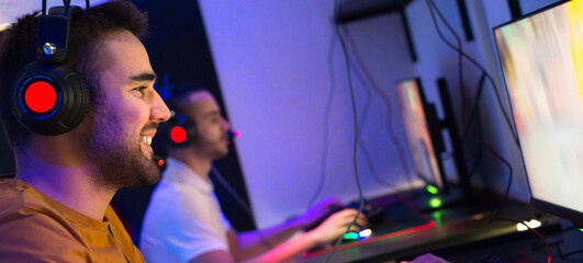 Team of gamers playing computer games at night