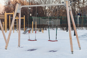 Fototapeta na wymiar empty swing at the playground in winter