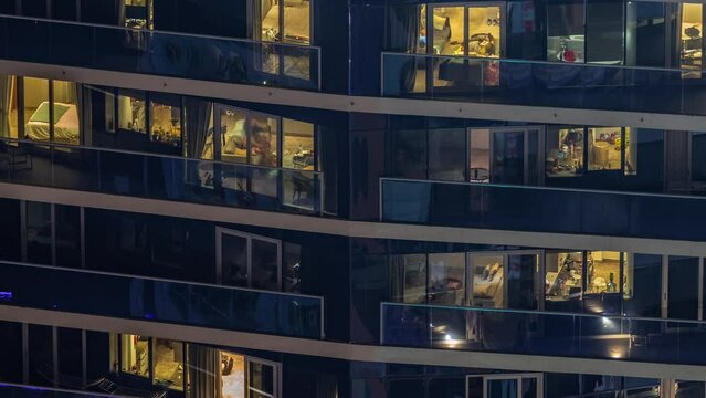 Evening view of exterior apartment recidential building timelapse with glowing windows. High rise illuminated skyscraper with lights. Relaxing zone on balconies
