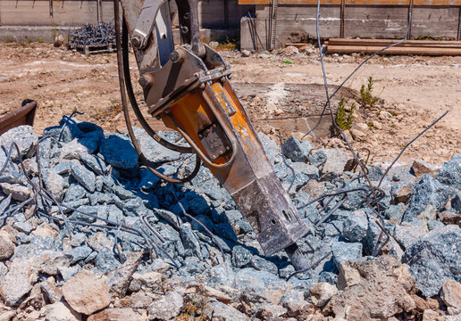 Excavator with demolition hammer in a construction site