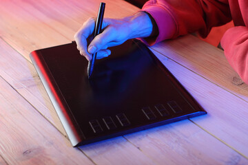 writing on a graphic tablet with a felt-tip pen by a person