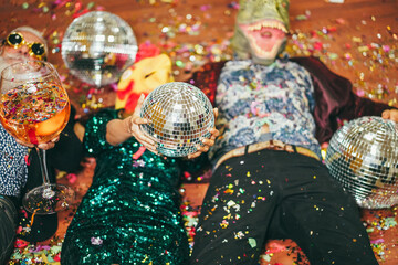 Crazy people celebrating carnival party inside nightclub - Focus on hands holding disco ball