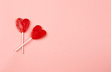 two heart shaped lollipops on light pink background, love concept, couple together, valentine's day celebration