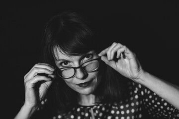 Hübsche Frau Portrait mit Brille vor dunklen Hintergrund