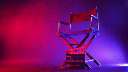 Director chair and clapper board in red and blue light color with black background