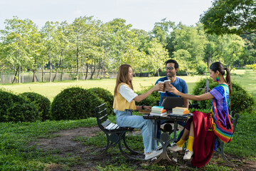 a new business creative team casual working together for a challenge startup project in park during weekend, young diverse friends sharing knowledge and brainstorming for school summer assignment