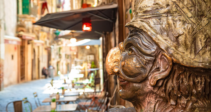 Via dei Tribunali street and sculpture of Pulcinella - popular tourist attraction in Naples city, Italy 2022