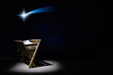 Nativity of Jesus, empty manger at night with bright lights.