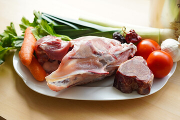 Ingredients for making Chicken broth with chicken bone, jamón bone and vegetables