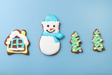 gingerbread snowman top view and house with christmas tree. different cookies on blue background