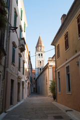 Fototapeta na wymiar Narrow street by the church of Saint Simeon with bell tower in Zadar, Croatia