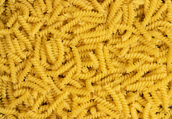 Uncooked gyrandole pasta. Top view of bright background image.