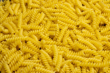 Uncooked gyrandole pasta. Top view of bright background image.
