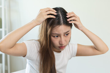 Damaged hair, face serious asian young woman, girl worry looking at scalp in mirror, hand in break into front hair loss, thin problem symptom from shampoo at home. Health care of beauty concept.