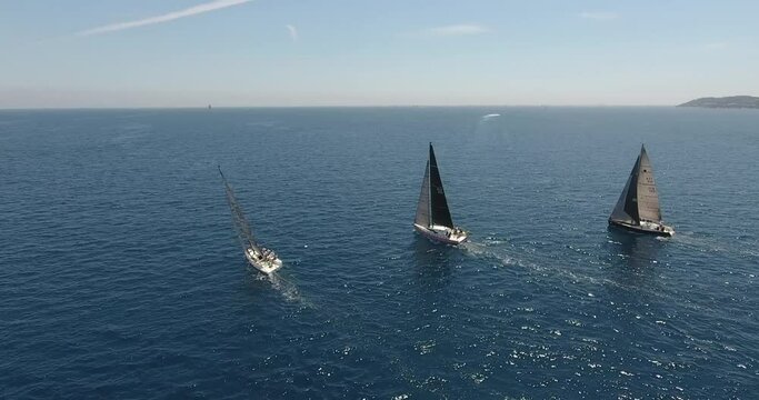 epic aerial view shots of the start of the Rolex Giraglia 2019 regatta, many sailing yachts have started and are making maneuvers dramatic sky