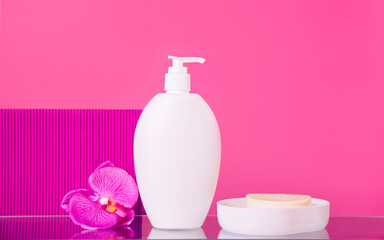 Blank mock up bottle beauty cosmetic skin care organic product for bathing routine with flower plumeria frangipani and soap in soap dish on purple background. Place your design.