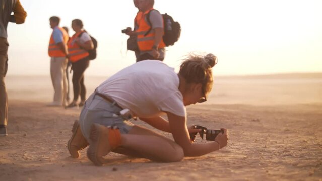 Girl shoots video on her phone in the steppe during a sandstorm. Filming. The film crew. Movie production