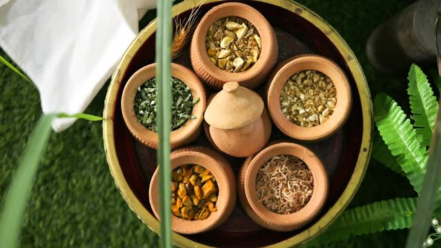 Variety of organic dry spices for spa: lemongrass, turmeric, pandan, kaffir lime, ginger. High quality 4K massage concept footage. Thailand.