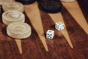 Two dice rolled on a backgammon game board. Backgammon game black versus white with dice. Backgammon set with rolling dice