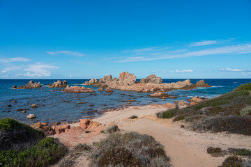 Rote Felsen am Strand und Meer an der Costa Paradiso auf Sardinien.