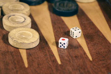 Two dice rolled on a backgammon game board. Backgammon game black versus white with dice. Backgammon set with rolling dice