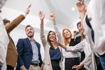 business team celebrate corporate victory together in office, laughing and rejoicing, smiling excited employees colleagues screaming with joy in office. - 553006139