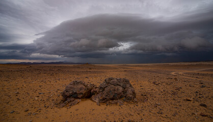 Cumulus clouds laden with rain cover the desert
