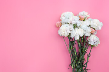 Bouquet of white carnations on a pink background isolated, flat lay.