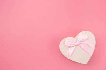 Gift box in the shape of a heart on a pink background isolated.