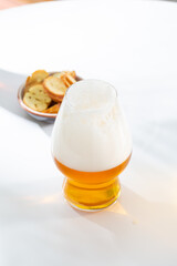 One glass with light craft beer food and drink on white table
