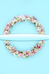 Obraz premium Easter wreath with apple blossom flowers on blue background, Natural floral composition, Spring flower Beltane equinox concept. Gradient banner copy space, top view, flat lay.