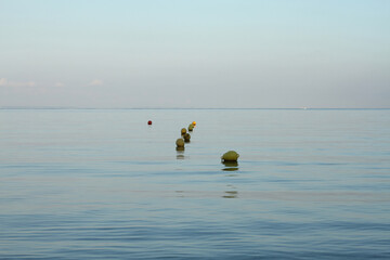 Early morning by the sea. Buoys on the surface of the sea.