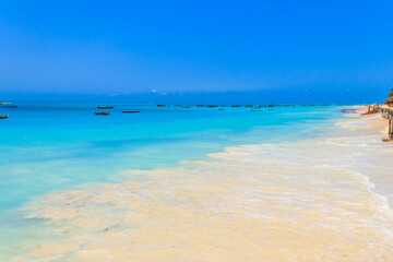 View of tropical sandy Nungwi beach and traditional wooden dhow boats in the Indian ocean on Zanzibar, Tanzania