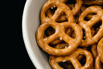 Close-up, pretzels in a plate on a black background.