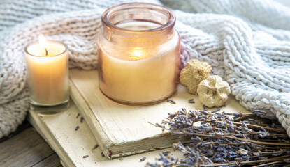 Still life with a candle and a knitted element.