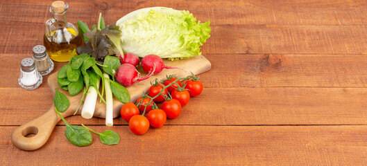 Fresh vegetables on cutting board placed on wooden table. Copy space for your text or logo or products. 