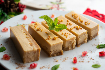Cheesecake and almond nougat. Typical Christmas dessert served on a table with Christmas decorations.