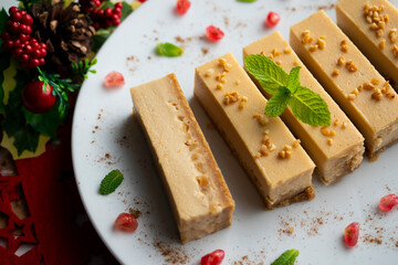 Cheesecake and almond nougat. Typical Christmas dessert served on a table with Christmas decorations.