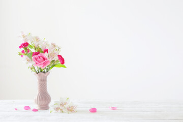 pink and white flowers in  vase on white background