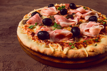 Pizza with prosciutto and mushrooms, bacon, olives, homemade, top view, no people,