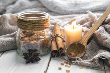 Composition with a candle and cinnamon sticks, close-up.